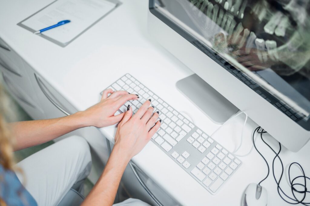 Orthodontist In The Dental Clinic Showing An X-Ray On The Computer